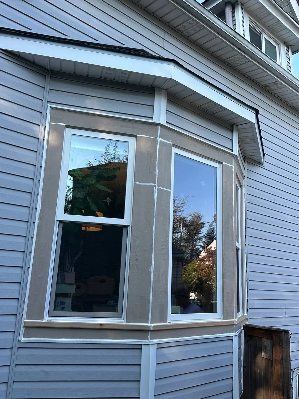New bay window installed in gray lap siding