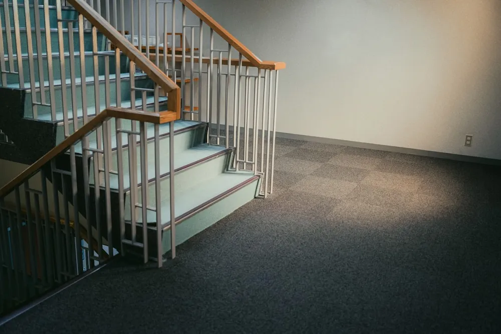 Commercial carpet tile installed in a stairwell landing with new stair treads