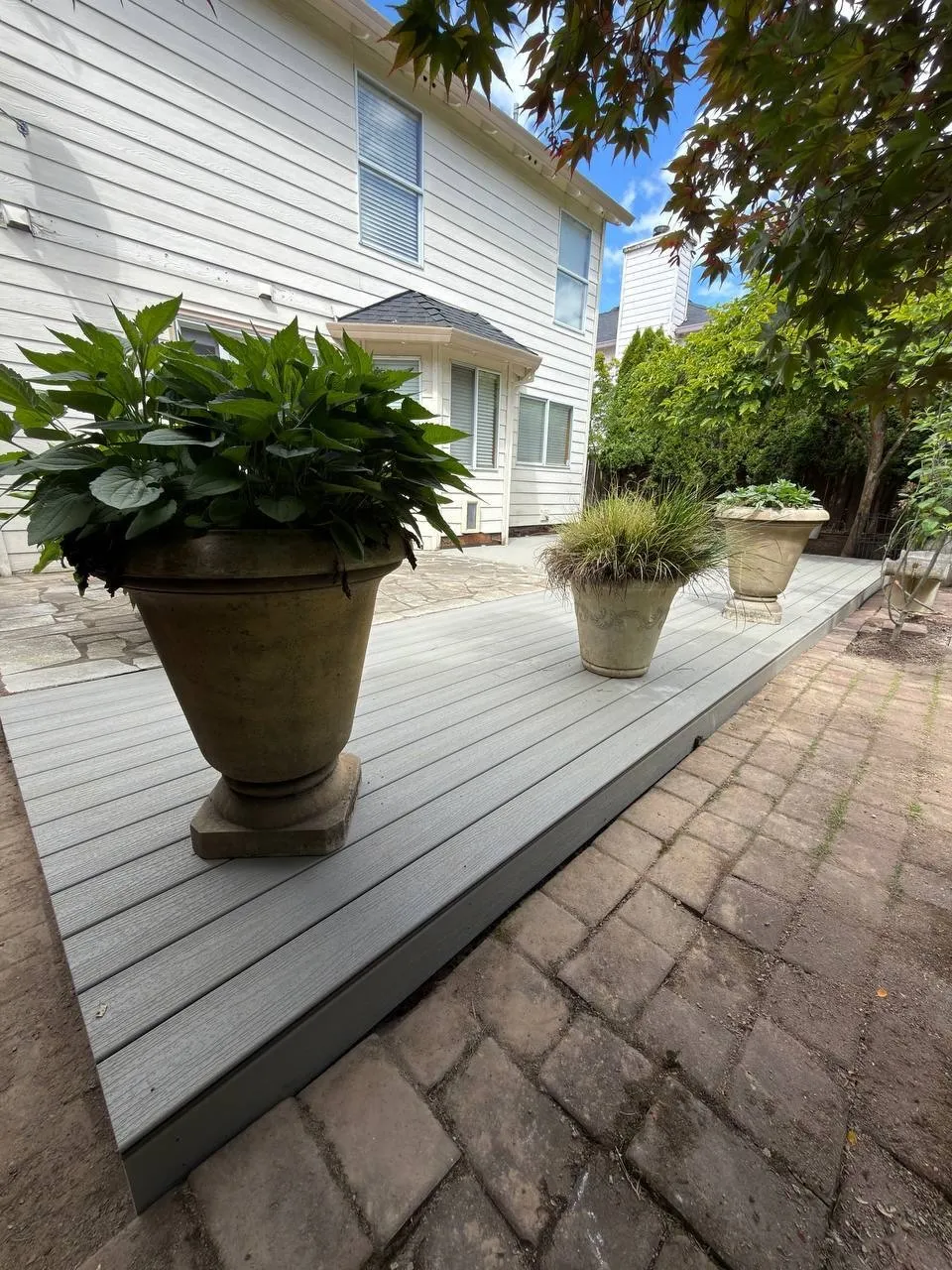 Composite deck edge with planters on a paver patio