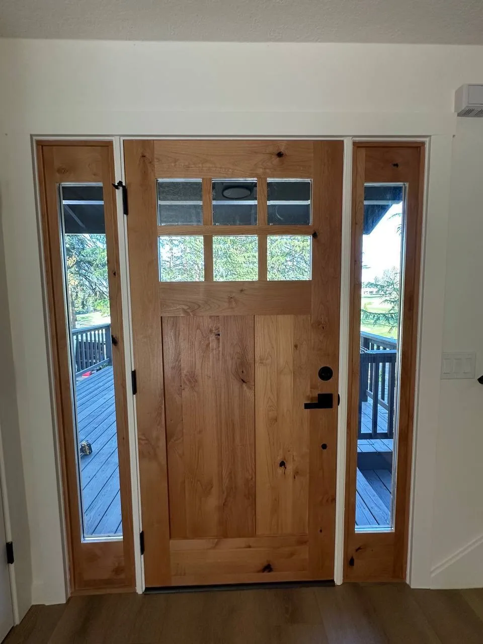 Wood craftsman entry door with sidelights installed in a home