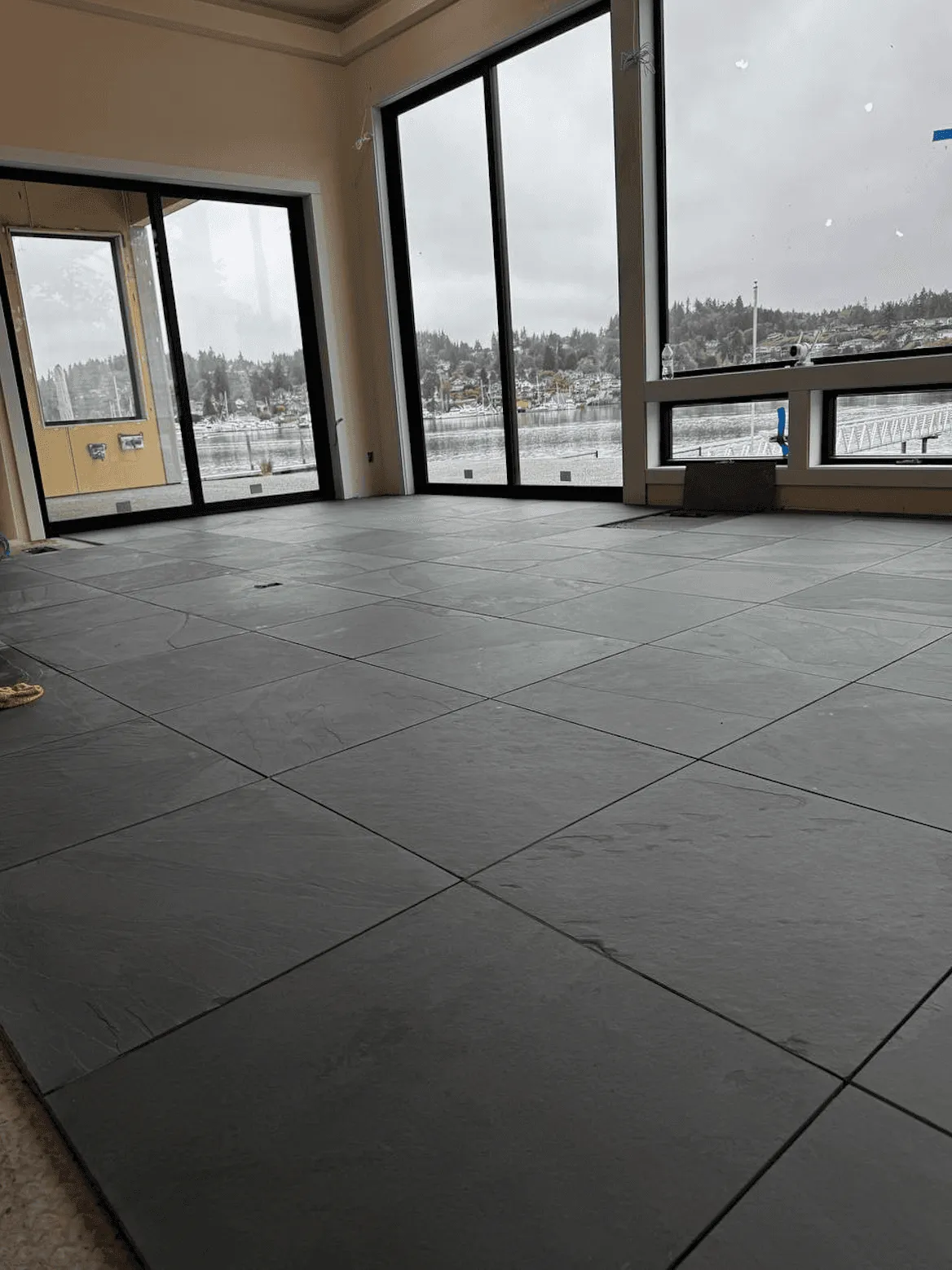 Large dark floor tile in a room with tall windows