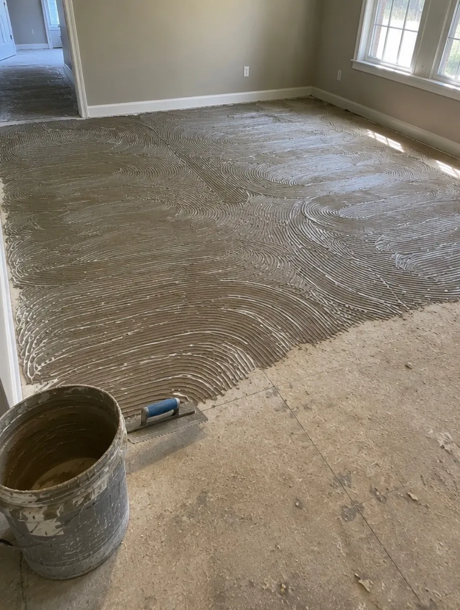 Self-leveling compound being troweled over a subfloor before new flooring