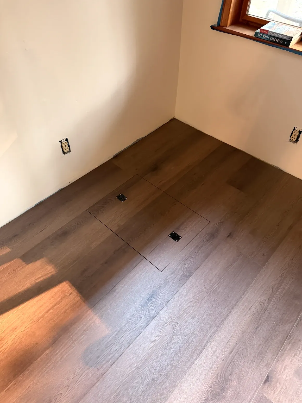 Floor access hatch covered with matching vinyl plank and two flush lift handles