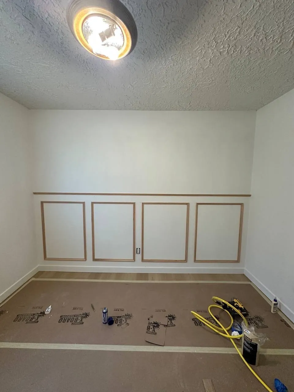 Wainscoting panels being installed on a bedroom wall