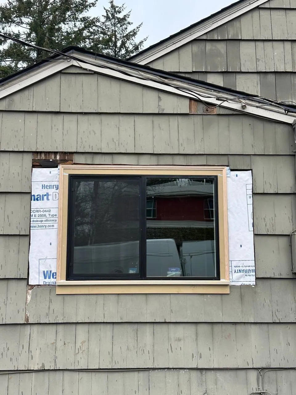 Replacement window set into shingle siding before trim